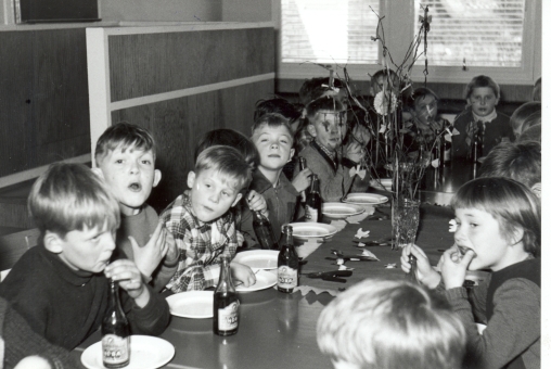 Børn ved festbord får serveret sodavand og kage