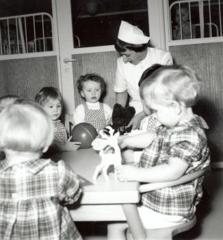 barneplejerske og børn ved et bord - børnene leger